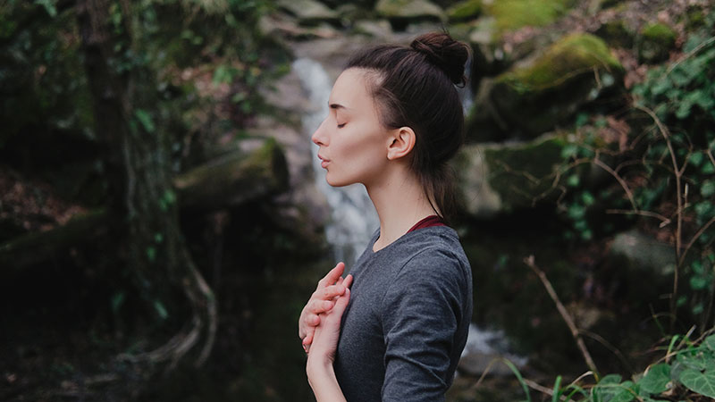 Young woman practicing breathing yoga pranayama